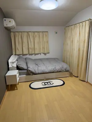 a bedroom with a bed and a rug on the floor at gt house in Tokyo