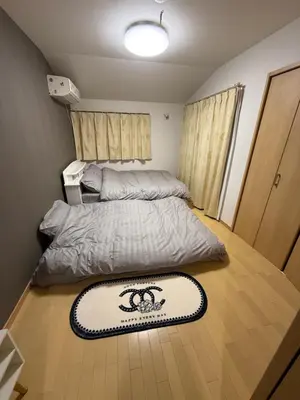 a bedroom with a bed and a rug on the floor at gt house in Tokyo