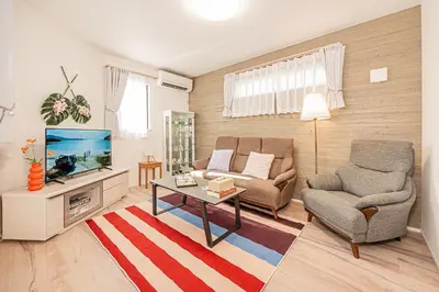 a living room with a couch and a tv at Minami Inn 3 bed rooms Villa 8 minutes walk from JR line Koiwa station For Family in Tokyo