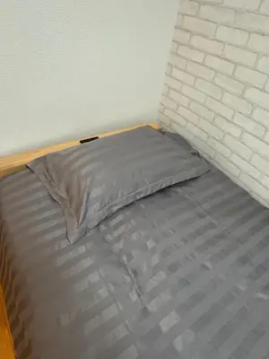 a bed with a pillow on top of it at 15 min to Shinjuku, 4 min walk to nearest station, quiet brand-new residence in Tokyo