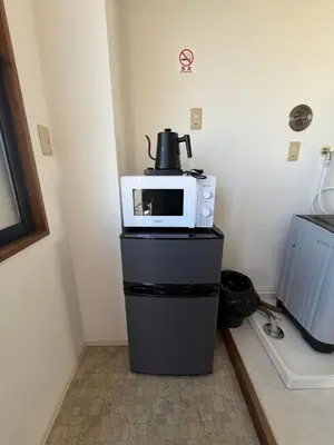 a microwave sitting on top of a black refrigerator at Kinjiro Hotel in Tokyo