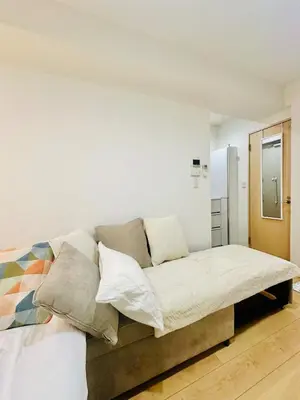 a bedroom with a couch with pillows on it at jlb\u30b0\u30e9\u30f3\u30a8\u30af\u30ea\u30e5\u521d\u53f0 102 in Tokyo