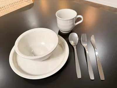 a table with a cup and a plate with a bowl and spoon at 52 House Nishi-Shimbashi in Tokyo