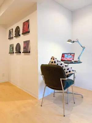 a chair in front of a wall with a laptop at 52 House Nishi-Shimbashi in Tokyo