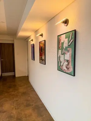 a hallway with three pictures on the wall at 52 House Nishi-Shimbashi in Tokyo