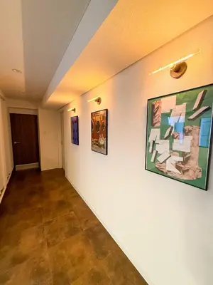 a hallway with paintings on the walls of a room at 52 House Nishi-Shimbashi in Tokyo