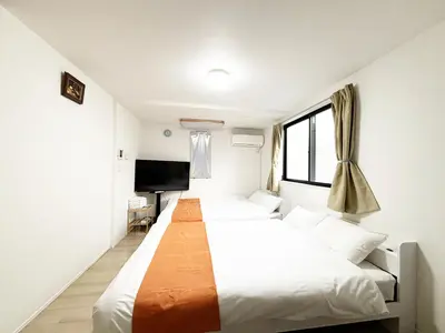 a bedroom with two beds and a flat screen tv at \u56db\u4eba\u90e8\u5c4b\u30d5\u30a1\u30df\u30ea\u30fc\u30bf\u30a4\u30d7 in Tokyo