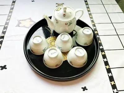 a black plate with a teapot and four cups at \u56db\u4eba\u90e8\u5c4b\u30d5\u30a1\u30df\u30ea\u30fc\u30bf\u30a4\u30d7 in Tokyo