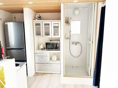 a small kitchen with a refrigerator and a microwave at \u56db\u4eba\u90e8\u5c4b\u30d5\u30a1\u30df\u30ea\u30fc\u30bf\u30a4\u30d7 in Tokyo