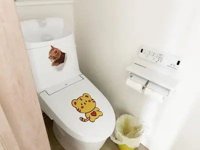 a cat sitting on top of a toilet in a bathroom at \u56db\u4eba\u90e8\u5c4b\u30d5\u30a1\u30df\u30ea\u30fc\u30bf\u30a4\u30d7 in Tokyo