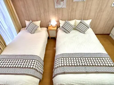 two beds sitting next to each other in a room at F2-Shibuya center 8mins to ST-Max 5P-\u4e58\u7535\u8f664mins\u53ef\u76f4\u8fbe\u65b0\u5bbf-\u5df4\u58eb\u76f4\u8fbe\u6e0b\u8c37\u516d\u672c\u6728\u94f6\u5ea7 in Tokyo