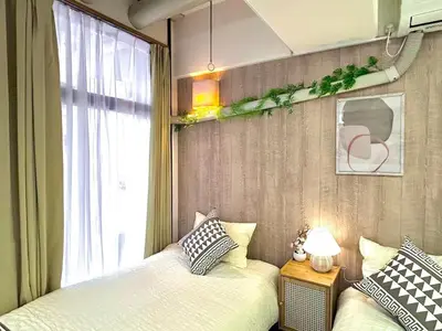 a bedroom with two beds next to a window at F2-Shibuya center 8mins to ST-Max 5P-\u4e58\u7535\u8f664mins\u53ef\u76f4\u8fbe\u65b0\u5bbf-\u5df4\u58eb\u76f4\u8fbe\u6e0b\u8c37\u516d\u672c\u6728\u94f6\u5ea7 in Tokyo