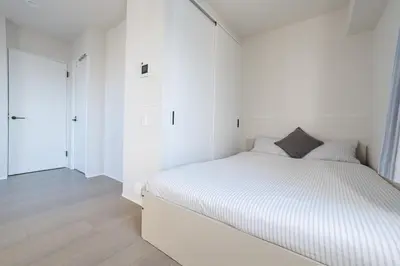 a white bedroom with a white bed and white cabinets at \u6d45\u8349\u99c5\u5f92\u6b69\u570f \u4ea4\u901a\u81f3\u4fbf \u6d45\u8349\u5bfa\u89b3\u5149 \u4ef2\u898b\u4e16\u30b7\u30e7\u30c3\u30d4\u30f3\u30b0 \u4e0b\u753a\u30b0\u30eb\u30e1\u6e80\u55ab \u6771\u6d45\u8349\u30b9\u30c6\u30a4 in Tokyo