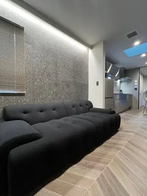 a black couch in a room with a wall at Koenji Designer house 50m2, 5min to Shinjuku in Tokyo