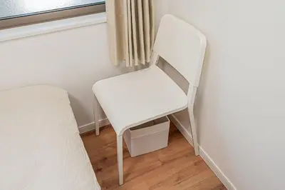 a white chair sitting next to a bed in a room at \u96f2 Yun \u5317\u5343\u4f4f\u8eca\u7ad9\u6b65\u884c11\u5206\u9418 \u76f4\u9054 Asakusa \u4e0a\u91ce \u79cb\u8449\u539f \u6674\u7a7a\u5854 \u65e5\u66ae\u91cc \u6d89\u8c37 \u8868\u53c3\u9053 \u6771\u4eac \u516d\u672c\u6728 \u9280\u5ea7 in Tokyo