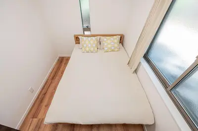 a small bed in a room next to a window at \u96f2 Yun \u5317\u5343\u4f4f\u8eca\u7ad9\u6b65\u884c11\u5206\u9418 \u76f4\u9054 Asakusa \u4e0a\u91ce \u79cb\u8449\u539f \u6674\u7a7a\u5854 \u65e5\u66ae\u91cc \u6d89\u8c37 \u8868\u53c3\u9053 \u6771\u4eac \u516d\u672c\u6728 \u9280\u5ea7 in Tokyo