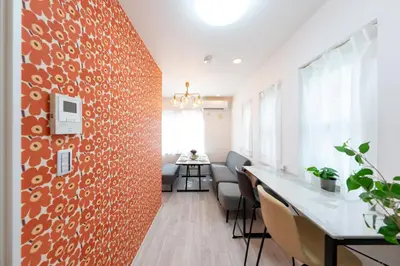 an office with a red wall with chairs and a table at Mic House SHINJUKU in Tokyo