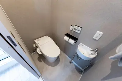 a small bathroom with a toilet and a sink at Mic House SHINJUKU in Tokyo