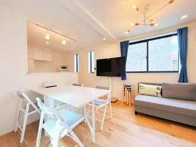 a kitchen and living room with a table and a couch at 5 min to JR Tabata Station Entire 3BR House 82sqm Sleeps 5 Hot Tub Newly Built in Tokyo