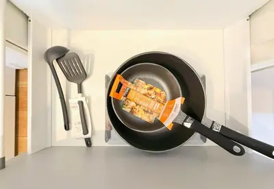 a frying pan with food in it next to a spatula at 5 min to JR Tabata Station Entire 3BR House 82sqm Sleeps 5 Hot Tub Newly Built in Tokyo