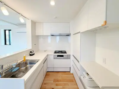 a white kitchen with a sink and a stove at 5 min to JR Tabata Station Entire 3BR House 82sqm Sleeps 5 Hot Tub Newly Built in Tokyo
