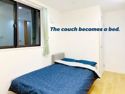 a bedroom with a bed with the couch becomes a bed at Newly Built Detached Villa 5 min walk to JR Tabata Station Yamanote Line in Tokyo