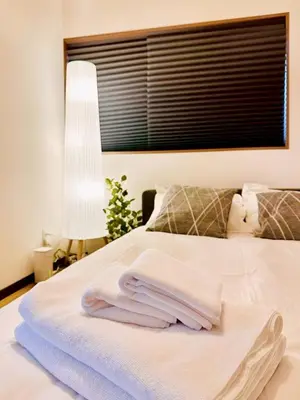 a pile of towels sitting on top of a bed at Astra house in Tokyo