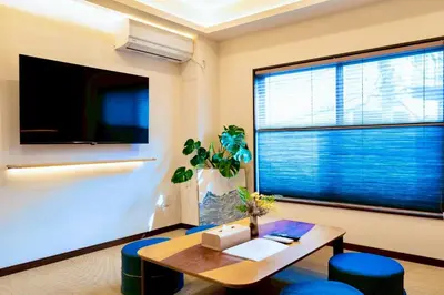 a living room with a table and a large window at Astra house in Tokyo
