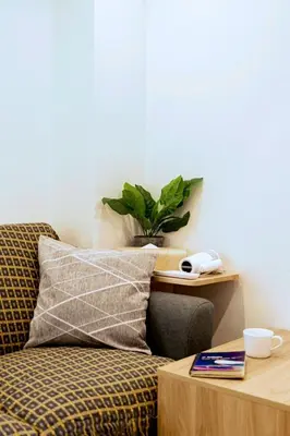 a room with a couch and a table with a plant at Astra house in Tokyo