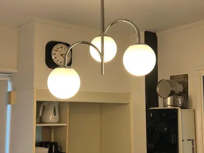 a kitchen with three lights hanging from the ceiling at Kuro House - In the middle of Hiro, Omotesando, Roppongi in Tokyo
