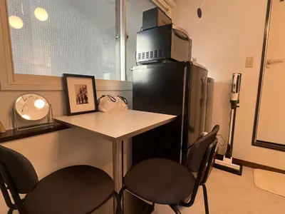 a kitchen with a small table and a refrigerator at Kuro House - In the middle of Hiro, Omotesando, Roppongi in Tokyo