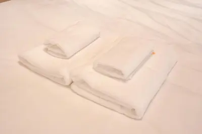 two white towels sitting on top of a bed at \u68ee\u4e0b\u30ad\u30fc\u30b3\u30fc\u30dd\u30db\u30c6\u30eb\u6700\u59278\u540d\u5bbf\u6cca\u53ef\u80fd in Tokyo