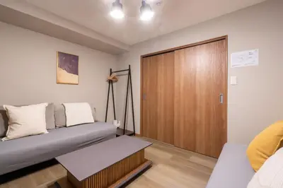 a living room with a couch and a sliding door at \u68ee\u4e0b\u30ad\u30fc\u30b3\u30fc\u30dd\u30db\u30c6\u30eb\u6700\u59278\u540d\u5bbf\u6cca\u53ef\u80fd in Tokyo