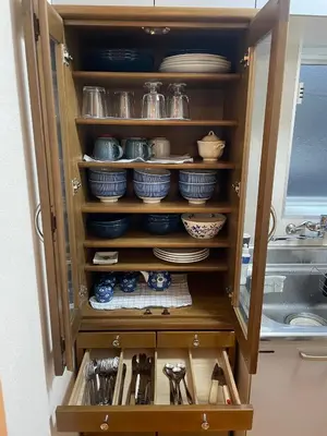 a cabinet filled with plates and dishes in a kitchen at \u767d\u3044\u5bb6\u5e83\u5c3e in Tokyo