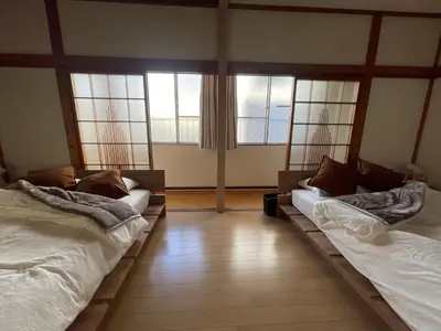 two beds sitting in a room with windows at \u767d\u3044\u5bb6\u5e83\u5c3e in Tokyo