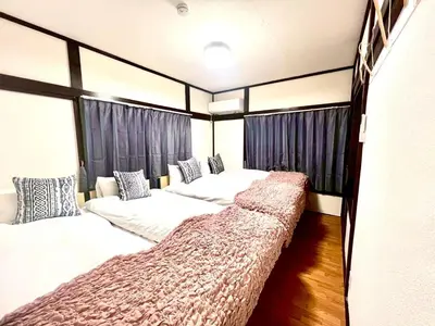 two beds in a room with windows at Minami Shinagawa House \u5357\u54c1\u5dddHouse in Tokyo