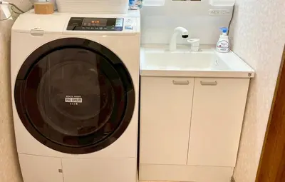 a washing machine in a kitchen next to a sink at Minami Shinagawa House \u5357\u54c1\u5dddHouse in Tokyo