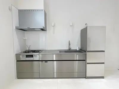 a kitchen with a sink and a stainless steel refrigerator at CIENtONCE BLD in Tokyo