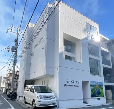 a white building with a car parked in front of it at CIENtONCE BLD in Tokyo