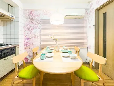a dining room with a wooden table and green chairs at \u6e0b\u8c37\u897f\u5ddd\u30d3\u30eb in Tokyo