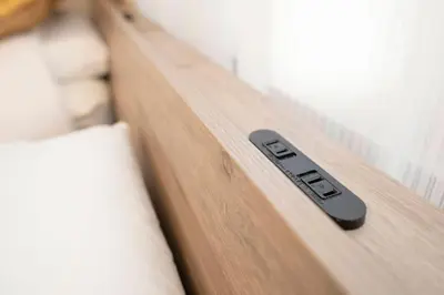 a black remote control sitting on a wooden shelf at XS60 XROSS STAY Toyosu1 in Tokyo