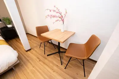 a table with two chairs and a vase with flowers on it at XS60 XROSS STAY Toyosu1 in Tokyo