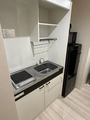 a kitchen with a sink and a black refrigerator at \u7d05\u8449\u306e\u9593-\u7573\u3067\u304f\u3064\u308d\u3050\u548c\u30e2\u30c0\u30f3\u6c11\u6cca in Tokyo