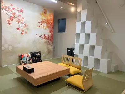 a living room with a table and chairs and a painting at \u7d05\u8449\u306e\u9593-\u7573\u3067\u304f\u3064\u308d\u3050\u548c\u30e2\u30c0\u30f3\u6c11\u6cca in Tokyo