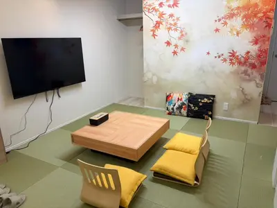 a living room with a table and chairs and a flat screen tv at \u7d05\u8449\u306e\u9593-\u7573\u3067\u304f\u3064\u308d\u3050\u548c\u30e2\u30c0\u30f3\u6c11\u6cca in Tokyo