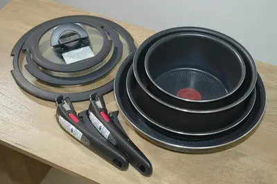 a table topped with black plates and two pairs of tongs at INA HOUSE Koiwa 202 in Tokyo