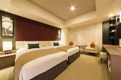 a hotel room with two beds and a desk at Tokyu Stay Ginza in Tokyo