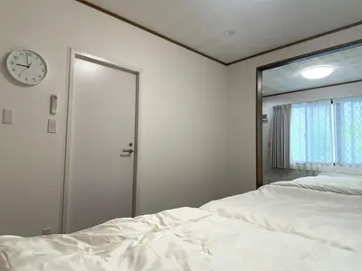 a bedroom with a bed and a clock on the wall at kSF\u6c60\u888b\u672c\u753a2\u4e01\u76ee in Tokyo