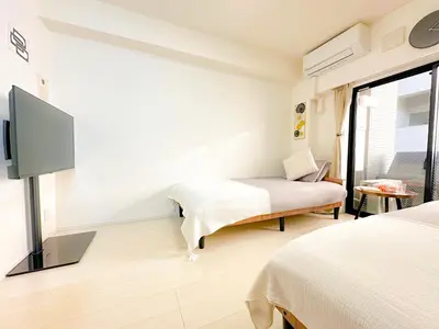 a bedroom with two beds and a flat screen tv at Shinjuku Center 2 Singles Cozy Apt, Free WiFi in Tokyo