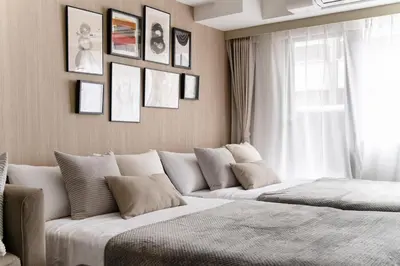 a living room with two beds and a window at Dogenzaka Hotel 306 in Tokyo